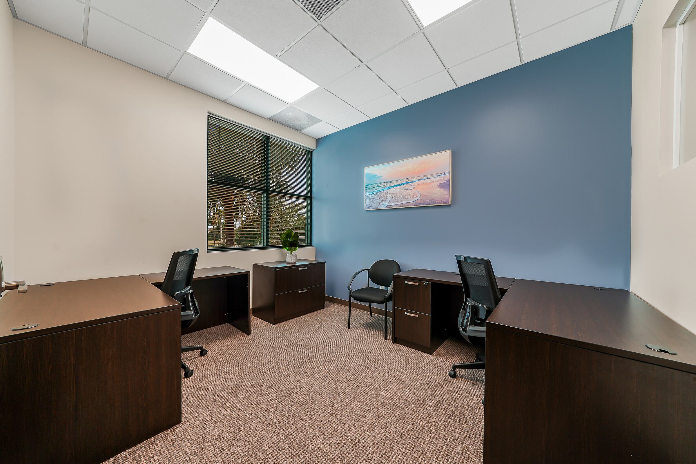 Furnished two-desk private office with a window at W Executive Suites St. Lucie West